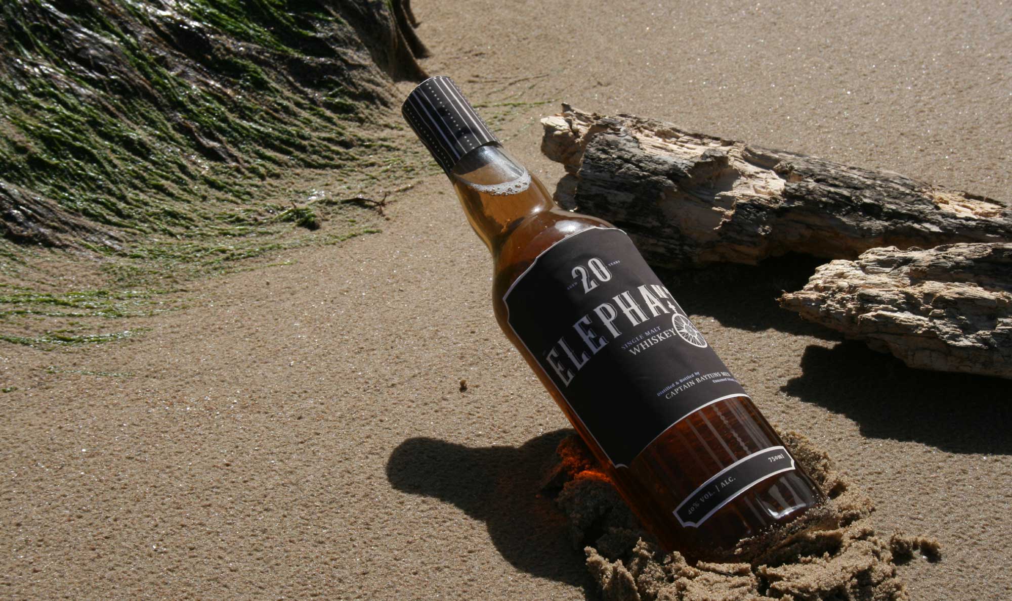 Photograph of the Elephant Whiskey bottle and label washed up on a beach, capturing the brand’s connection to maritime history. Designed by Creative Footing.
